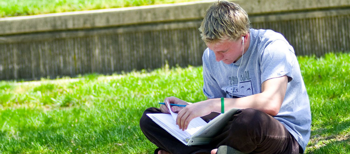 Student studying outside the UMBC Commons facing the Quad